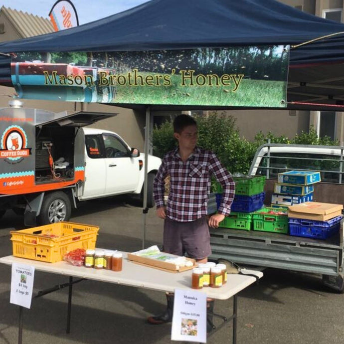 mason brothers selling honey at a farmers market