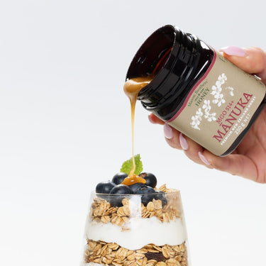Pouring Mason Btohers Manuka Honey MGO 514+ onto granola and berries